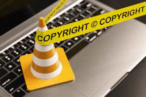 Copyright warning barrier on laptop representing creator rights to terminate copyright transfers and reclaim ownership of creative works