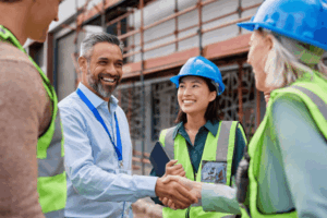 Construction business owner and contractors handshaking on job site representing credibility gained through federal construction company trademark registration