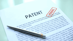A close-up of a patent document with a red 'PENDING' stamp, representing the time before a patent is granted and its term length is finalized.