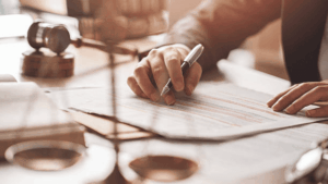 Trademark attorney reviewing and signing non-traditional trademark registration documents with gavel and legal scales