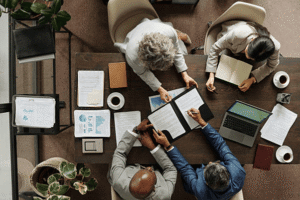 Business team reviewing interstate trademark conflict documents and brand name rights strategy during legal dispute resolution meeting