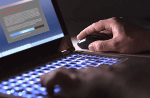 Unidentified person secretly copying trade dress and visual brand identity on laptop representing how businesses quietly lose brand identity through digital theft
