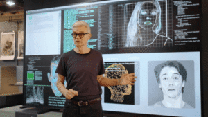 AI researcher presenting deepfake facial mapping technology highlighting the need for trademark strategies to protect brands from synthetic media misuse