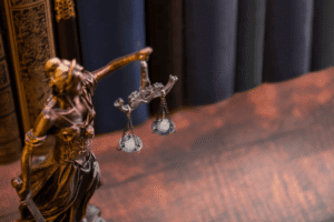 Lady Justice scales statue with law books representing balanced legal proceedings in TTAB trademark opposition and dispute resolution before the USPTO