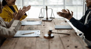 Legal team celebrating successful trademark coexistence agreement negotiation around conference table with justice scales and gavel